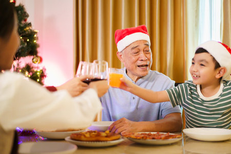 Happy cheerful Asian family is celebrating Christmas and New Year dinner party together, a family...
