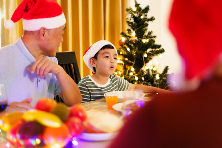 Happy cheerful Asian family is celebrating Christmas and New Year dinner party together, a family with mother, father and son. Asian lovely family celebrate Christmas - New Year festival.の写真素材
