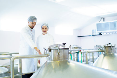 Team of quality control officers or factory engineers are inspecting inside the beverage...