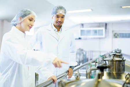 Team of quality control officers or factory engineers are inspecting inside the beverage...