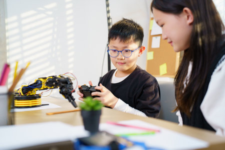 Asian boy and girl are enjoy studying with STEM toys together, STEM is Sciences, Technology, Engineering, and Mathematics. Children are learning about robotics and coding.の写真素材