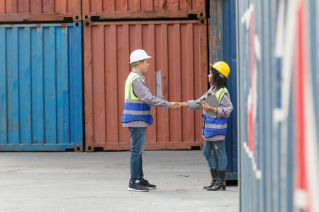 Businesswoman and ship yard engineer are having a discussion about oversea import and export...