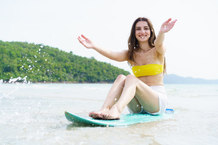 Good looking Western woman enjoys posing with a surfboard on a sunny beach day, capturing joyful summer moments and reflecting outdoor travel, freedom, and holiday relaxation by the ocean.の写真素材