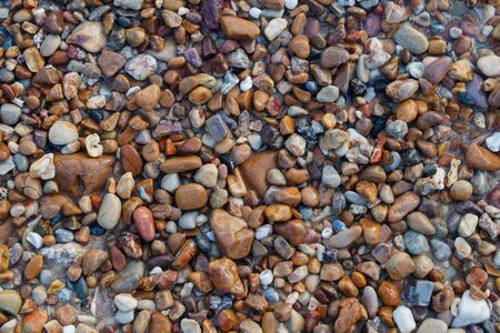 Naturally rounded gravel at sea shore, nature beach background textureの写真素材