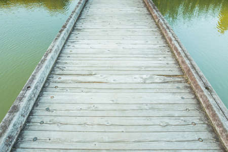 Wooden Bridge over a Pond in the Parkの写真素材