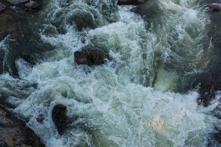 Water flowing over rocks on top view.の写真素材