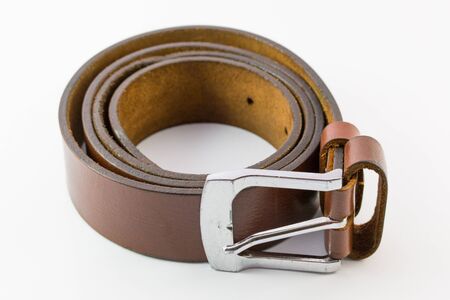 Old leather belt roll on white background.の写真素材