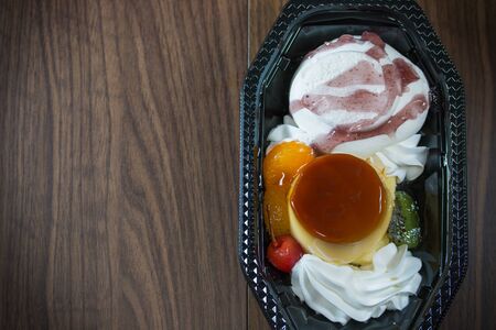 Ice cream mix caramel custard pudding with fruit delicious on wooden background  vintage style.の写真素材