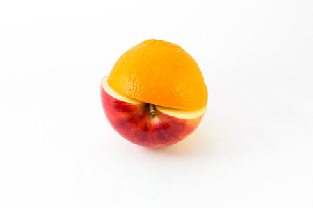 Creative apple combined from red apple and orange half isolated on white. Conceptの写真素材