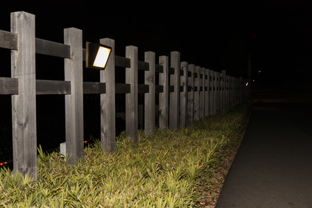 Wooden fence against lamp in night.の写真素材