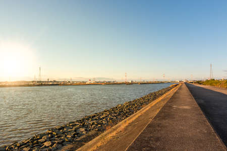 Road along a river at sunset in autumn.の写真素材