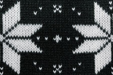 Detailed knitted black jacquard pattern with white flowers.の写真素材