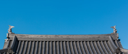 Traditional roof of ancient japanese building with blue sky.