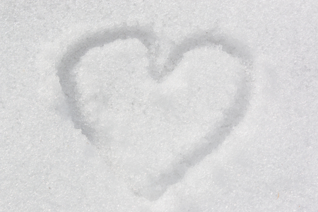 The symbol of the heart, painted on the fresh white snowの写真素材