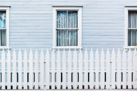 White wooden country style fence with windows of house at behindの写真素材