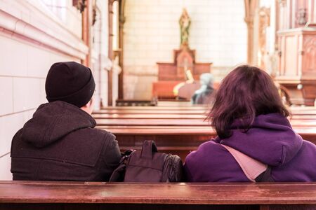 men in church interior sitting back on praying.のeditorial素材