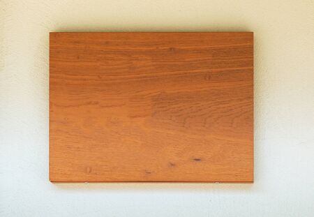 Blank wooden signboard on cement wall with shiny under roof.の写真素材