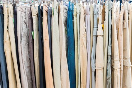 clothes hanging on a rack in a flea market stall.の写真素材