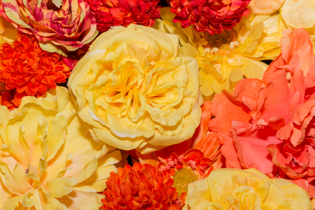 Beautiful orange artificial flowers background. flowers decor.の写真素材
