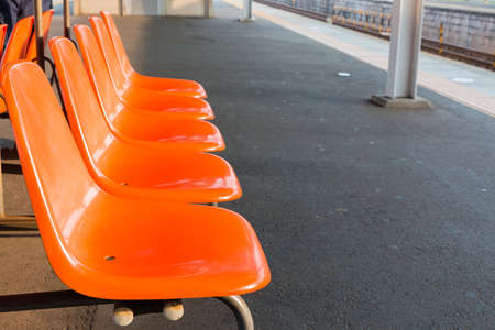 Rows of an empty orange plastic seats in railway station. empty seats.の写真素材
