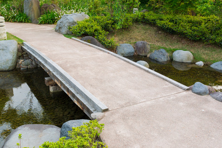 Stone path in a Japanese Garden, stone bridge, across a tranquil pond.の写真素材