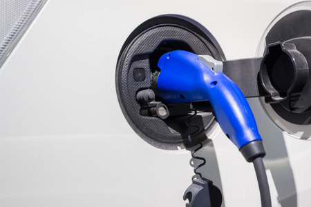 Electric Car Being Charged. Charging an electric car with the power supply plugged in. about business electric car industrial.の写真素材