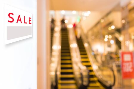 Sale signboard with Abstract blurred background of Department store interior cloth fashion zone.の写真素材