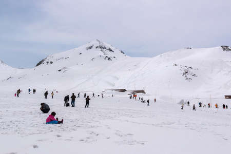 Tateyama, Japan - 2 May 2016: Tourists walk along snow corridor. This snow wall is a part of Kurobe Alpine Route which offers spectacular views around Tateyama mountain.のeditorial素材