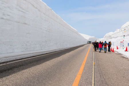 Tateyama, Japan - 2 May 2016: Tourists walk along snow corridor. This snow wall is a part of Kurobe...