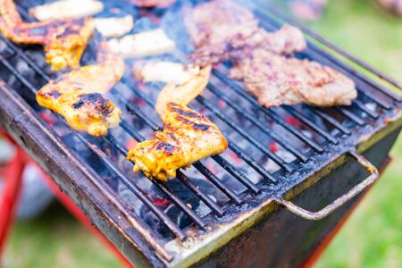 Cooking BBQ meat at festival outdoor in park. Concept of summer party with families and friends.の写真素材