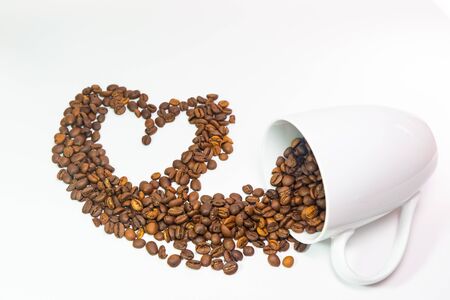 Coffee beans in coffee cup on white background with heart shape for those who like coffeeの写真素材