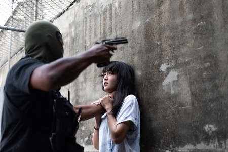Crime concepts robbery aimed his gun at an asian girl, Low key concept
