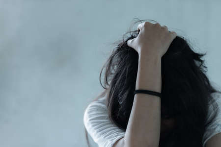 Asian girl hopeless concept after using drug addict feeling be absent-minded, Lonely girl concept in dark roomの写真素材
