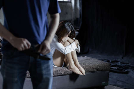 Man taking off the pants before violence sexual rape young woman at abandoned house, robber criminal rape conceptの写真素材