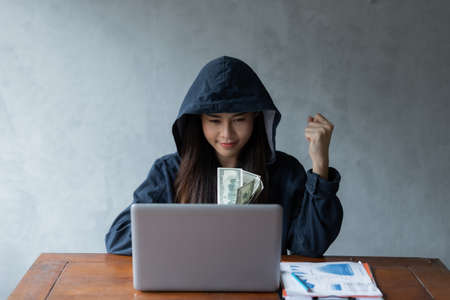 Hacker asia woman stealing data success from online computer systems by using laptop. concept of business malware and hackerの写真素材
