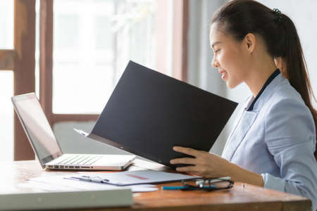Business asian woman working at home and see information from laptop. Business, finance and technology concept.の写真素材