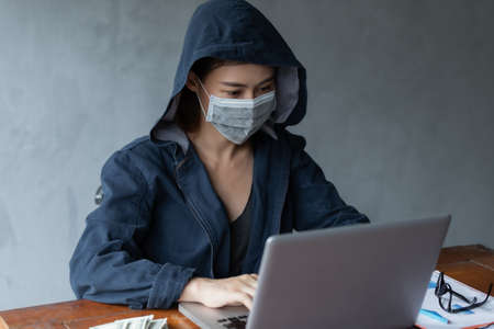Hacker asia woman stealing data from online computer systems by using laptop. concept of business malware and hackerの写真素材