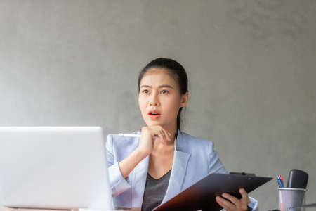Business asian woman working at home and see information from laptop. Business, finance and technology concept.の写真素材