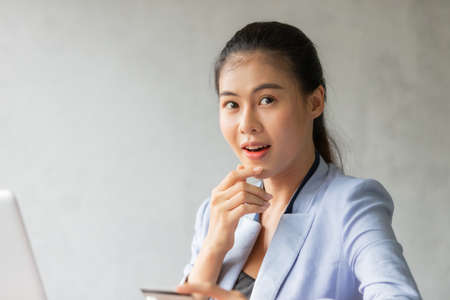Young asian woman using credit card and laptop for online shopping at home office, smile and happy feeling businesswoman lifestyle conceptの写真素材