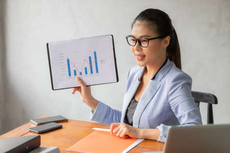 Business asian woman working at home and see information from laptop. Business, finance and technology concept.の写真素材