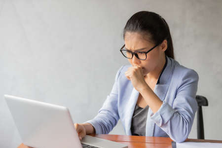 Business asian woman working at home and see information from laptop. Business, finance and technology concept.の写真素材