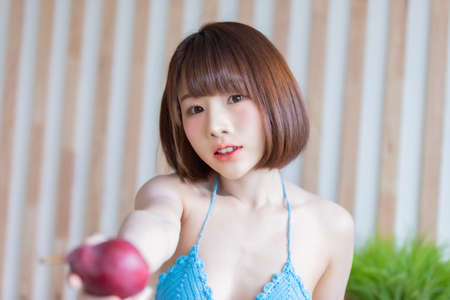 Portrait of young pretty sexy Asian woman wearing blue bikini in her room. Sexy girl feeling happy concept.の写真素材