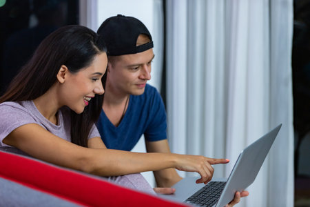 Young couple relaxing and enjoying at home on sofa with laptop. Concept happy couple.の写真素材