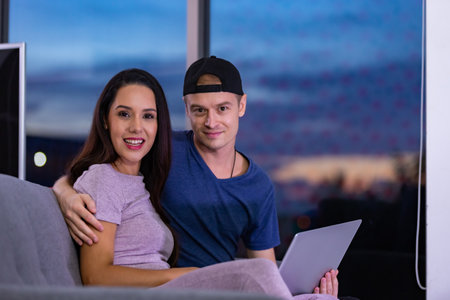 Young couple relaxing and enjoying at home on sofa with laptop. Concept happy couple.の写真素材