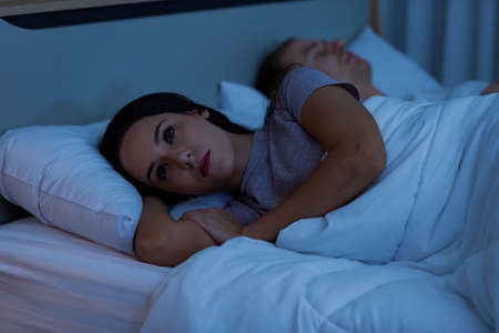 Young woman lying on the bed, that is sad quarrel with husband.の写真素材