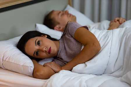 Young woman lying on the bed, that is sad quarrel with husband.の写真素材