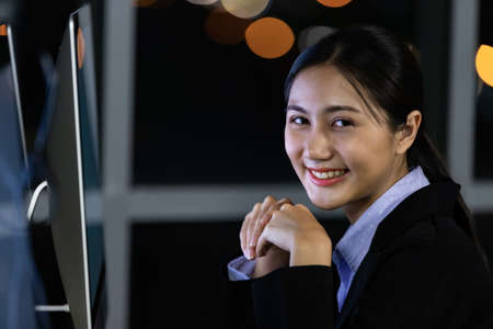Portrait business young woman working overtime late at night in call center office. Concept for business at night.の写真素材