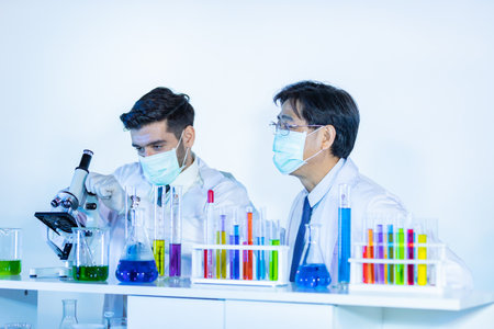 Team of research scientists analysing test trial new generation vaccine data. They work in a modern laboratory/ Medical center.の写真素材