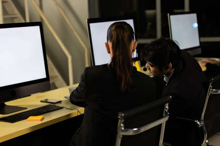 Businessman talking with team and working overtime late at night in call center office. Concept for...