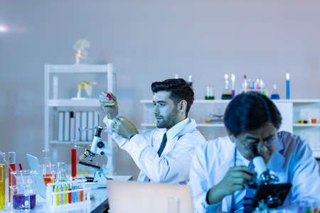 Team of research scientists analysing test trial new generation vaccine data. They work in a modern...